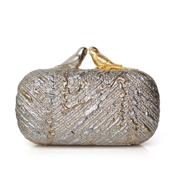 Silver and gold metallic clutch bag topped with two birds one silver and one gold on a white background