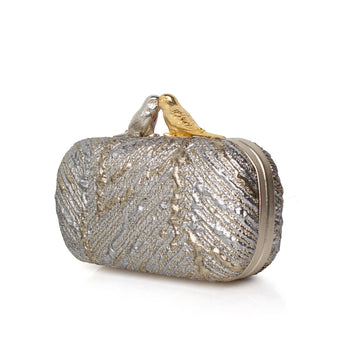 Silver and gold metallic clutch bag topped with two birds one silver and one gold on a white background