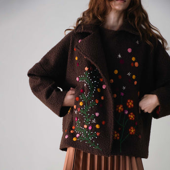 Brown jacket with floral embroidery on a plain background