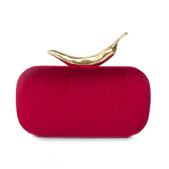 A red velvet clutch with a sculpted metallic chili pepper clasp.