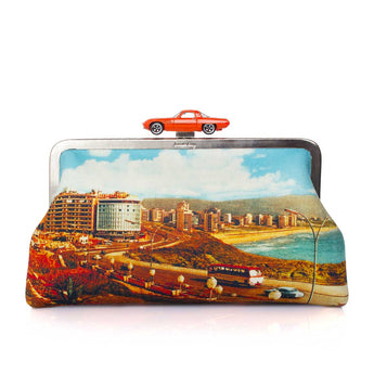 A classic clutch bag featuring a colorful printed scenic design of a coastal city and beach, with a small red toy car mounted on top of the frame, set against a plain white background.
