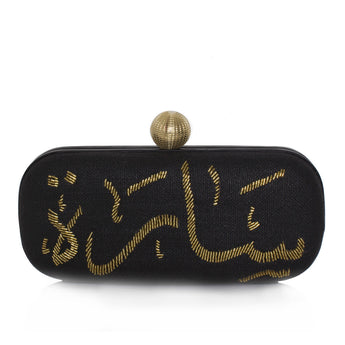 A black clutch with gold calligraphy geometric patterns and a gold clasp on a white background.