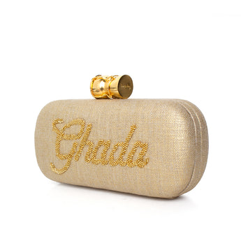 Gold clutch bag with calligraphy name  embroidery and a champagne buckle on a white background