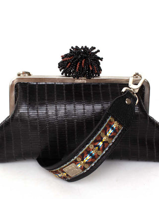 Black textured leather clutch bag with a beaded dhalia clasp and a  strap on a white background