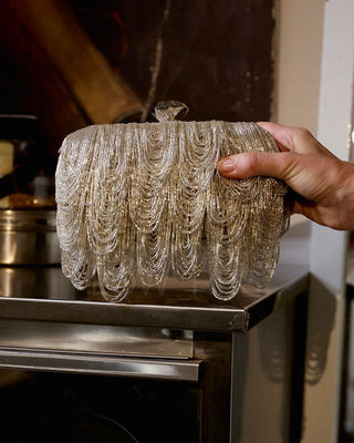 Decorative chandelier bag beaded design on a metallic surface.