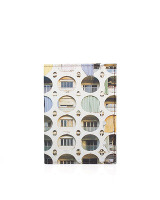 A slim leather passport cover featuring a photographic print of a modernist building facade with circular arches and windows, shown on a plain white background.