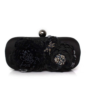 Black clutch bag with floral embellishments and beads on a white background