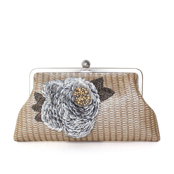 A handcrafted clutch bag with a floral pattern, made from recycled Nespresso capsules, predominantly beige in color with gray and brown accents.