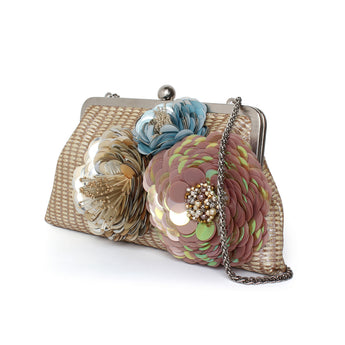 A straw handbag with floral embellishments in pastel colors.