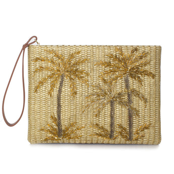 A gold straw clutch with gold palm trees beadwork and a brown leather wrist strap.