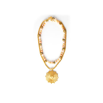 The Heart Rays Gold Necklace with Sunrise Pearls features a sculpted heart at the center of the pendant, paired with a strand of softly colored pearls