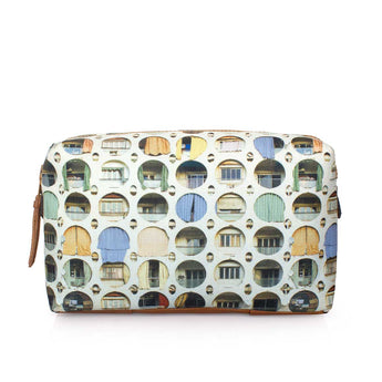 A rectangular zippered pouch featuring a repeating pattern of colorful arched windows on a white background, with a brown leather zipper pull on the left side.