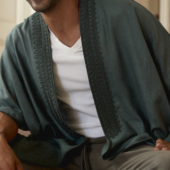 Person wearing a green embroidered abaya over a white shirt