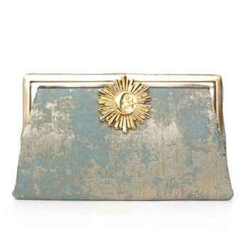 Gold and blue clutch bag with moon rays clasp on a white background