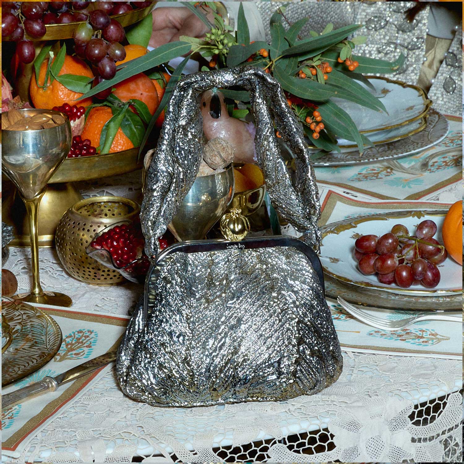 Gold metallic handbag with a pomegranate clasp on a a table