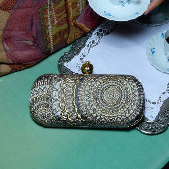 Big box clutch bag with sunburst patterns on a green background 