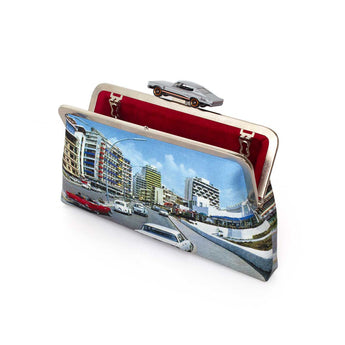 A classic bag with a printed city street scene on the exterior, featuring a red interior lining and a silver metal frame with a car-shaped clasp.