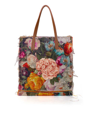 Floral patterned tote bag with brown handles on a white background
