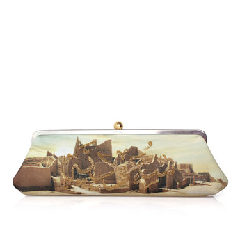A rectangular clutch bag with a metal frame and clasp, featuring a printed scenic artwork of ancient ruins with draped gold chains, set against a plain white background.