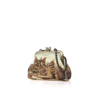 A vintage-style kiss-lock clutch bag featuring a printed landscape scene with mountains, trees, and a boat, accented with gold beadwork details and a black chain strap.