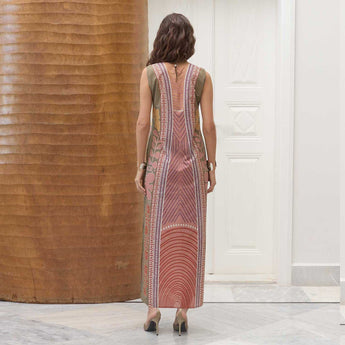 Woman wearing a pastel patterned vanda dress standing in a room with wooden and white walls.