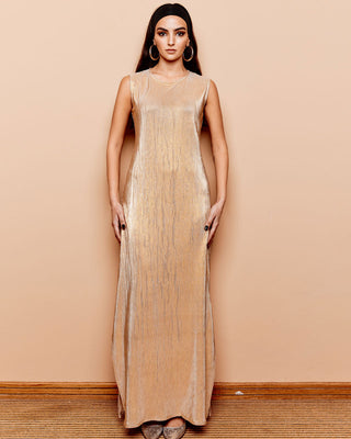A model wearing a sleeveless, ankle-grazing gold maxi dress with vertical pleats.